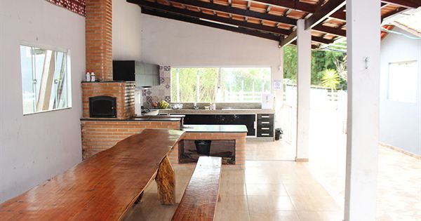 Refeitório com mesa de madeira e cozinha da unidade da Reabilitação BH em Nova Serrana (MG)